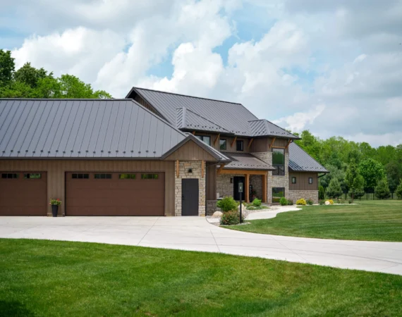 A large house with a driveway and lawn.